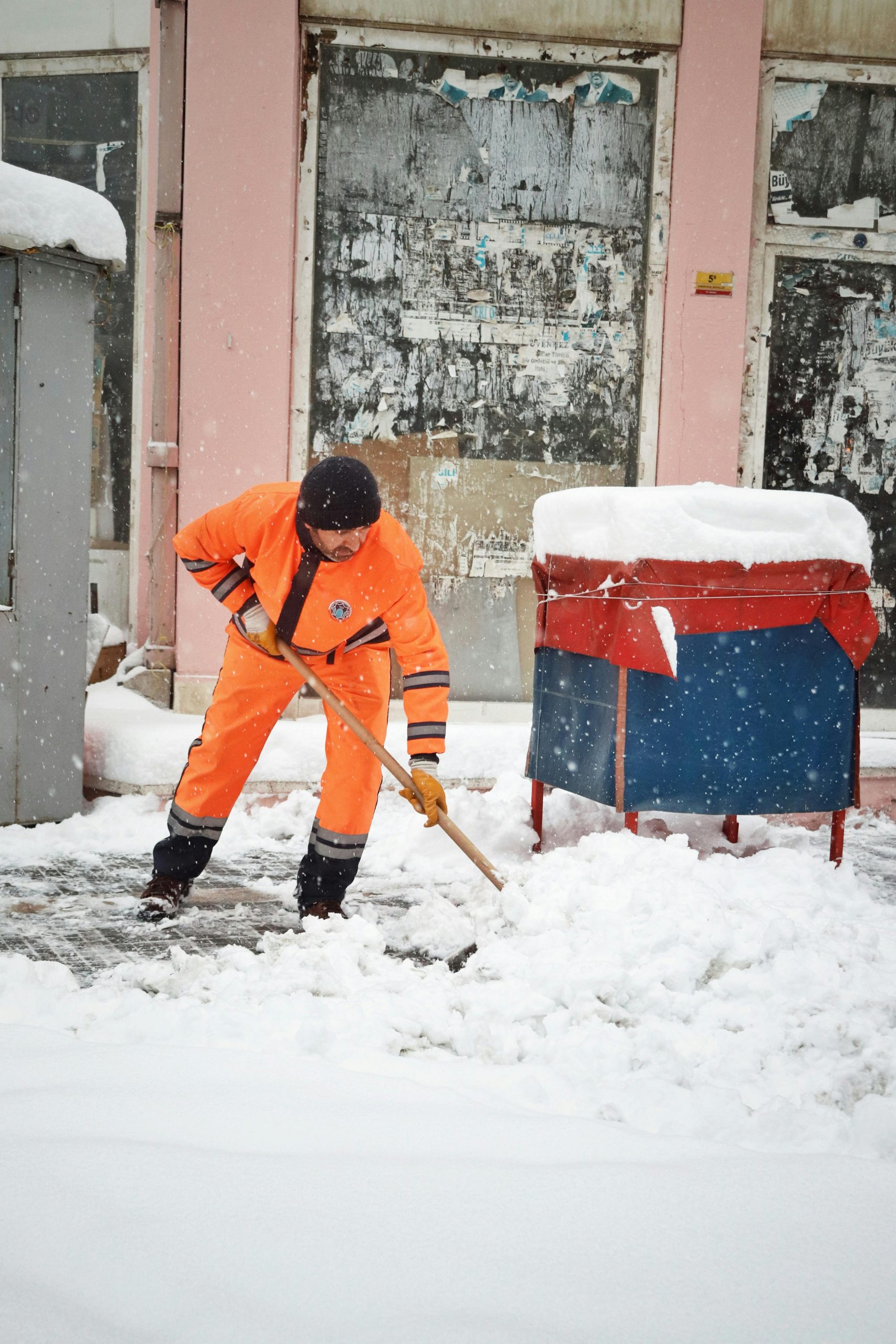Leistungen 4 A municipal worker shovels snow on a city street in Malatya, Türkiye, during winter.